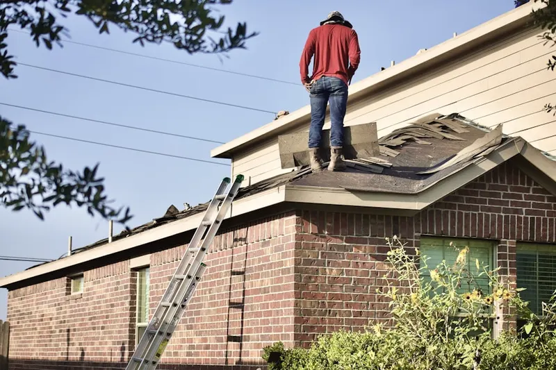 Professional roofer working on a residential roof in Crossmans
